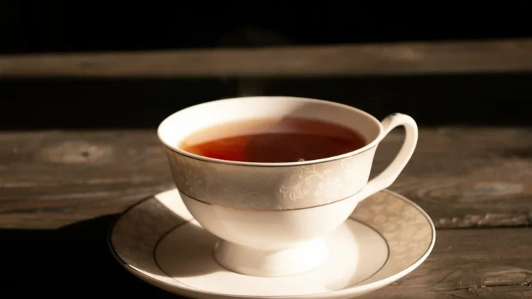 A cup of tea on a saucer resting on a wooden table